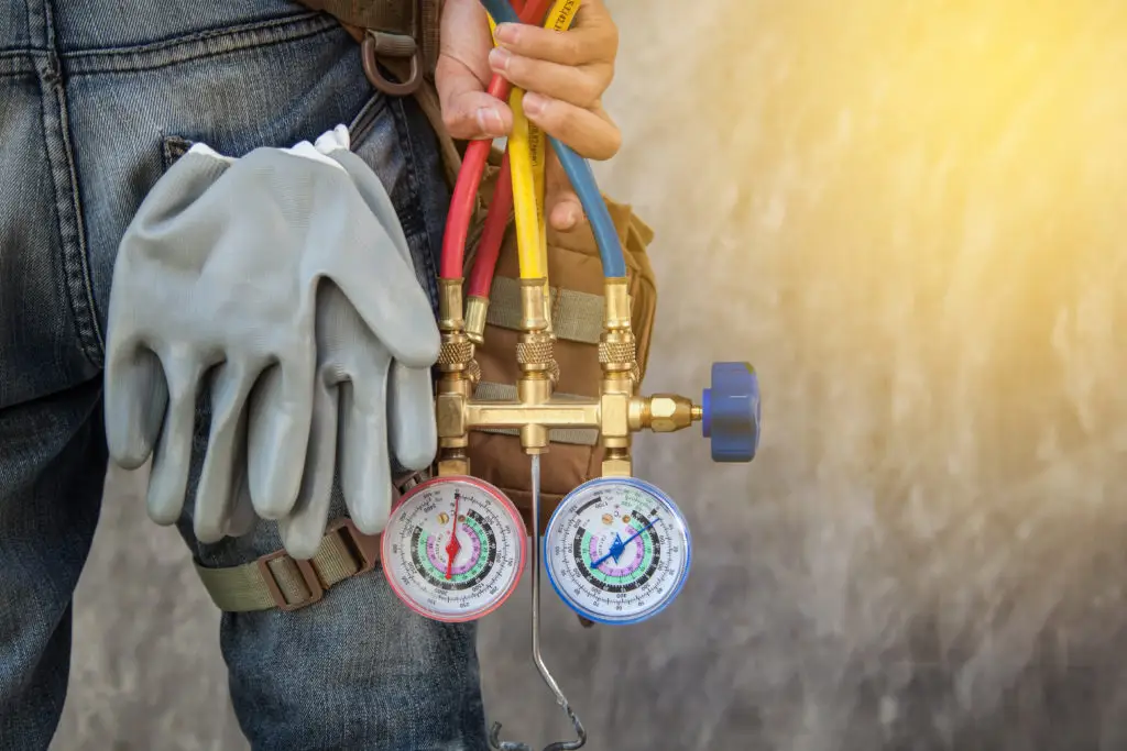 Air conditioning technician checking for leaking refrigerant