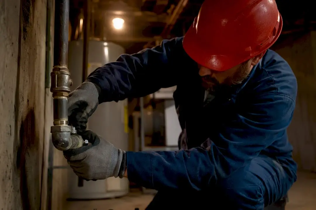 Technician inspecting gas line valve in basement