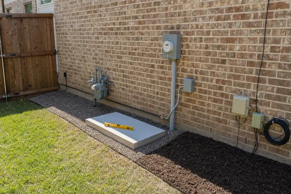 Composite generator pad on gravel, Sunnyvale, TX New composite generator pad set level on compacted gravel beside a brick home in Sunnyvale, TX, before the generator is placed